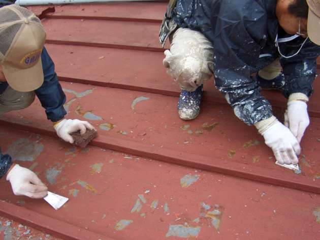 トタン屋根をケレンして劣化した古い塗膜を削り落とす