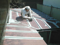 トタン屋根の凹凸部から下塗りをしていく